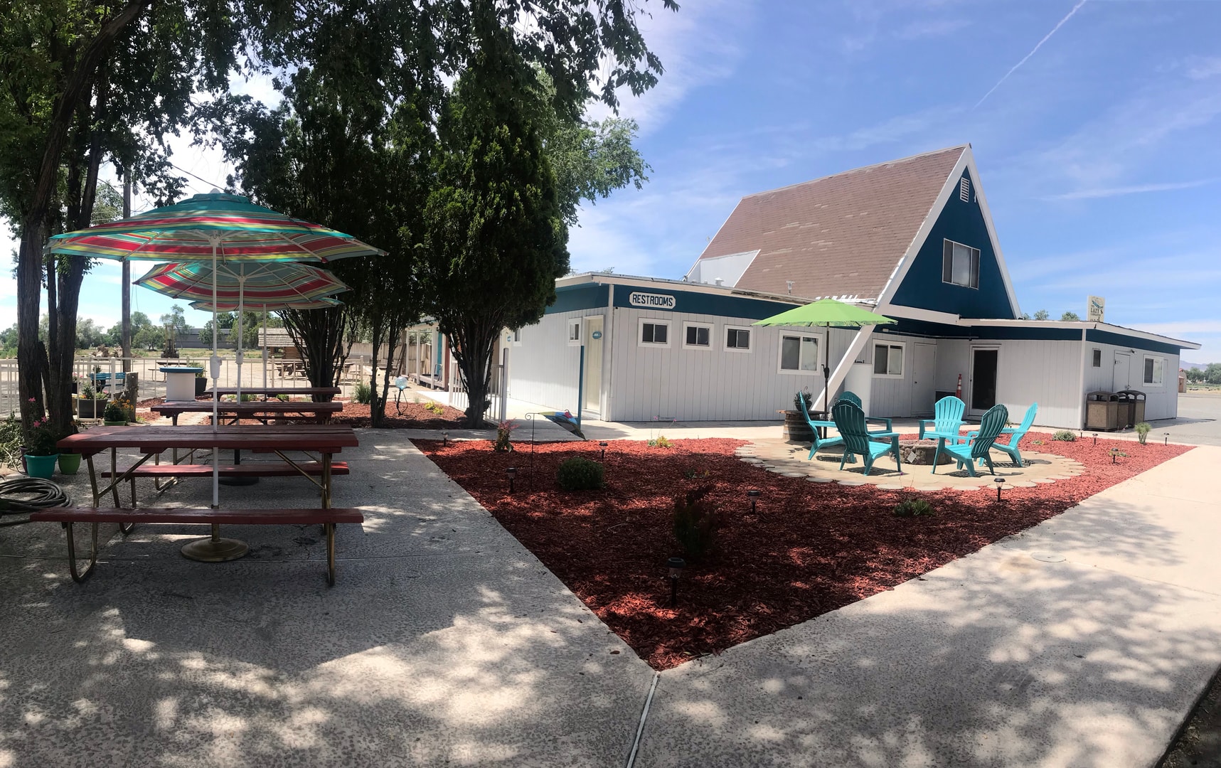 Outdoor recreational area with picnic tables and Adirondack chairs